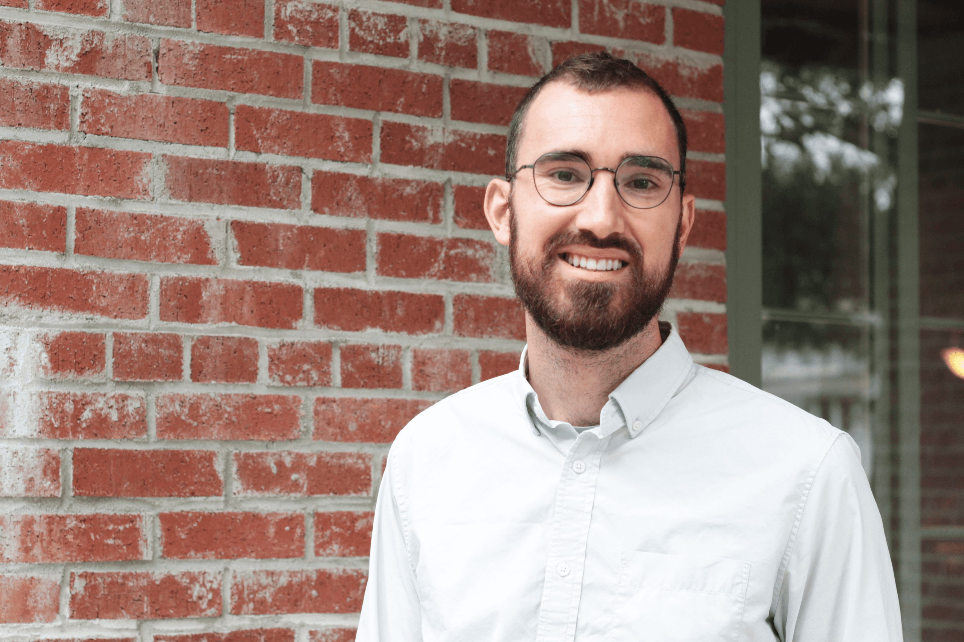 Troy Robinson standing in front of a brick wall